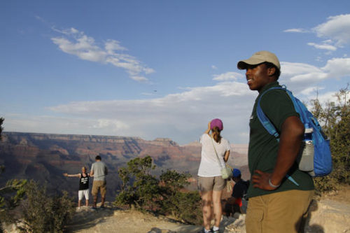Grand Canyon National Park intern Mi-Kal White looks waits for visitors to approach him for assistance on July 26, 2016. As the National Park Service prepares to celebrate its 100th anniversary on Aug. 25, the agency is working to attract more minorities to the country's national parks and monuments as the demographics of America are expected to change dramatically in the coming years.