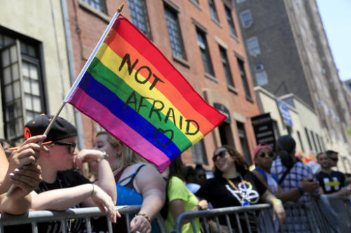 FILE - In this June 26, 2016, file photo, a woman holds a rainbow flag during the NYC Pride Parade in New York.