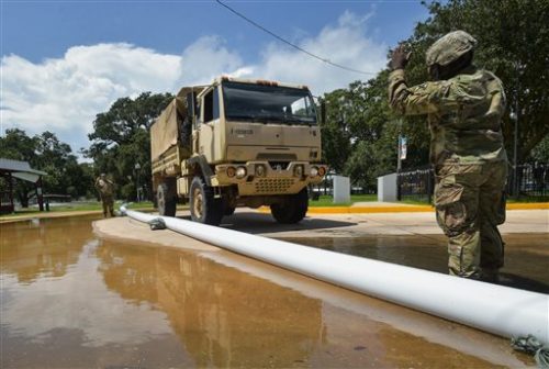 Members of the Louisiana Army National Guard help place sandbags to protect the city hall in Lake Arthur, La., Wednesday, Aug. 17, 2016.