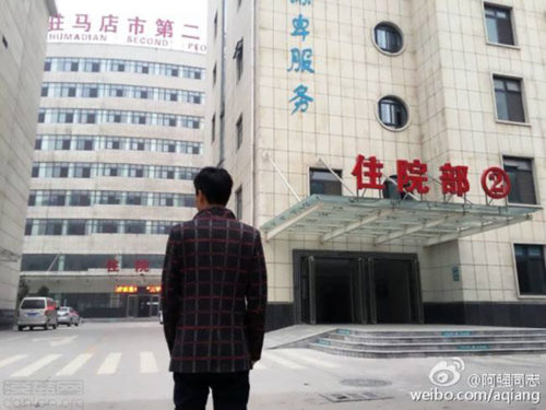Yu Hu stands in front of Zhumadian Psychiatric Hospital.