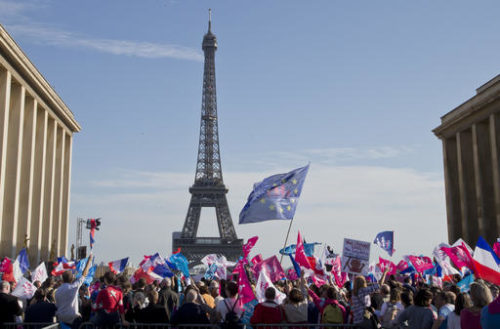 Demonstrators wave flags at Trocadero plaza to protest gay marriage in Paris, Sunday, Oct. 16, 2016. Thousands of people have marched in Paris to call for the repeal of a law allowing gay marriage, six months before France's next presidential election. Eiffel tower in the background.