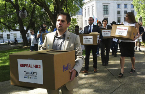 FILE - In this April 25, 2016, file photo, State Rep. Chris Sgro, D-Guilford, who is also executive director of Equality NC, leads a group carrying petitions calling for the repeal of House Bill 2 to Gov. Pat McCrory's office at the state Capitol building in Raleigh, N.C. As North Carolina has a bit of an identity crisis, its election for governor and even president will be a referendum on the state’s right turn and contentious new laws. "North Carolina IS a progressive state," insists Sgro. "What really happened is that in a low-turnout year, Democrats lost in 2010, and Republicans slammed our state with the worst possible redistricting that turned everywhere in the state into unwinnable conservative districts."