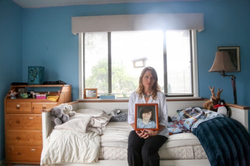 Katharine Prescott holds a framed photo of her transgender son, Kyler.