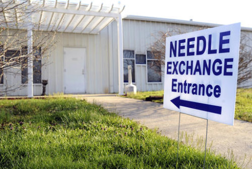 FILE - In this April 4, 2015 file photo, a sign points to the entrance of the Community Outreach Center in Austin, Ind. The long decline in HIV infections among white people who inject drugs has stalled, another grim side effect of the nation’s drug abuse epidemic. Health officials released the news Tuesday, Nov. 29, 2016, as part of a call for more use of needle exchange programs. Last year rural Scott County experienced an HIV outbreak, in which more than 100 injection drug users were infected. The state’s governor at the time - Mike Pence, now the vice president-elect - declared a public health emergency and authorized a limited need-exchange program to prevent the virus from spreading further.