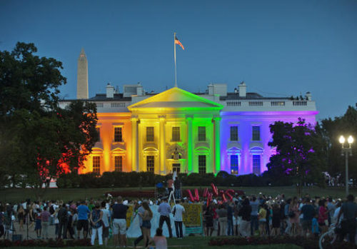 FILE - In this Friday, June 26, 2015 file photo, people gather in Lafayette Park to see the White House illuminated with rainbow colors in commemoration of the Supreme Court's ruling to legalize same-sex marriage in Washington. It was a new look for the White House: illuminated in rainbow colors to celebrate the Supreme Court decision allowing same-sex marriage nationwide. President Barack Obama, who was inside, felt the glow on that June night in 2015. To see people gathered in the evening outside on a beautiful summer night, and to feel whole and to feel accepted, and to feel that they had a right to love _ that was pretty cool," he said a few days later.