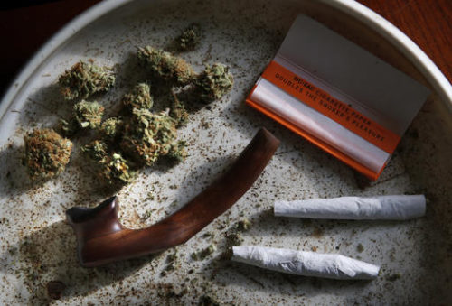FILE - This this Nov. 21, 2014, file photo shows medical marijuana, a pipe, rolling papers and two joints in Belfast, Maine. The first tangible results of state voters’ decision to legalize marijuana are being felt as possession and home growth of marijuana becomes legal Monday, Jan. 30, 2017. Voters narrowly passed the ballot question in November, and the waiting period between the vote and legalization has expired.