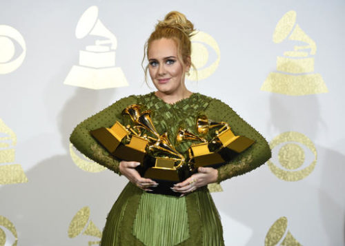 Adele poses in the press room with the awards for album of the year for "25", song of the year for "Hello", record of the year for "Hello", best pop solo performance for "Hello", and best pop vocal album for "25" at the 59th annual Grammy Awards at the Staples Center on Sunday, Feb. 12, 2017, in Los Angeles.