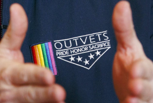 OutVets founder Bryan Bishop wears the logo of his group while speaking with a reporter at his house in Boston, Friday, March 10, 2017. The organizers of Boston's embattled St. Patrick's Day parade have scheduled an emergency meeting to reconsider their vote to shut out the gay veterans group. This week's decision to bar OutVets from marching drew immediate condemnation from high-profile politicians and stirred up a furor on social media.