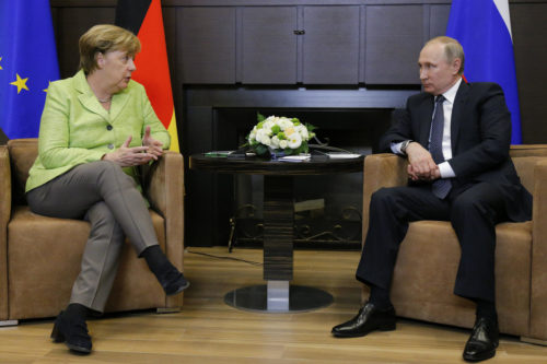Russian President Vladimir Putin, right, and German Chancellor Angela Merkel talk during their meeting at Putin's residence in the Russian Black Sea resort of Sochi, Russia, Tuesday, May 2, 2017. Merkel Putin