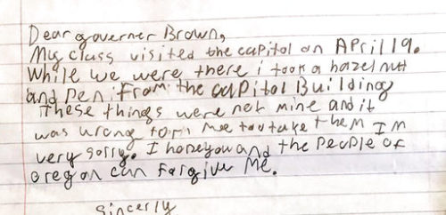 This photo provided by the Office of Oregon Gov. Kate Brown shows a portion of an apology letter from a fourth-grader to Gov. Brown, explaining that his class had toured the Capitol on a field trip in April 2017 and how he took a hazelnut and a pen from the Capitol Building. In a note replying to the letter, which included the pen in question and a $1 reimbursement for the hazelnut, Brown thanked the young man and wrote "I accept your apology and forgive you." (Saerom England/Office of Oregon Governor Kate Brown via AP)