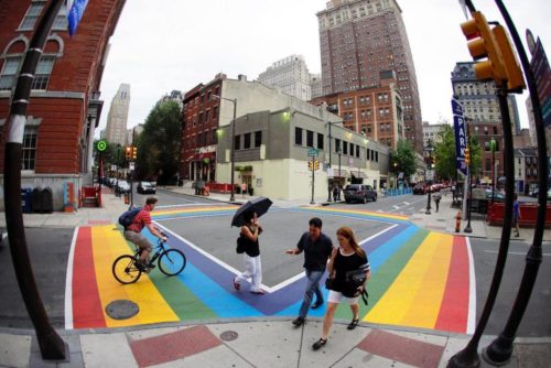 People walk across a rainbow crosswalk in support of the LGBT community at the intersection of 13th and Locust streets, Thursday, June 25, 2015, in Philadelphia. Philadelphia rainbow crosswalk