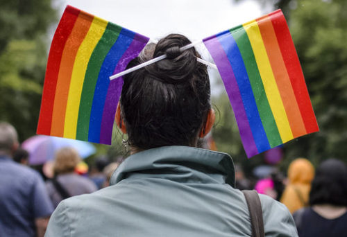 A woman with rainbow colored flags in her hair waits for the start of a gay pride parade in Bucharest, Romania, Saturday, May 20, 2017. Some 1,000 people have joined a gay pride march in the Romanian capital of Bucharest on Saturday, demanding greater rights amid government moves they say will curtail their human rights.