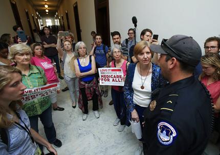 Protesters against the Republican health care bill talk to US. Capitol Police officer near the office of Senate Majority Leader Mitch McConnell of Ky., Monday, July 17, 2017, on Capitol Hill in Washington. republican healthcare bill