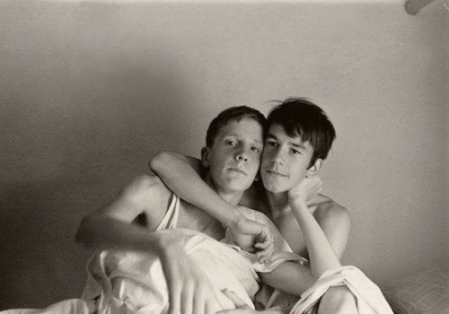A gay couple embracing in bed