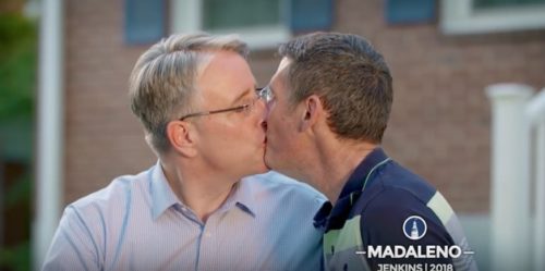 Richard Madaleno kisses his husband, Mark Hodge, in his latest campaign ad. Richard Madaleno kisses his husband, Mark Hodge, in front of their home.