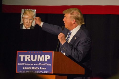 Presidential candidate Donald Trump holds up a magazine cover featuring himself while at a campaign stop at the Mid-America Center in Council Bluffs, Iowa. Presidential candidate Donald Trump holds up a magazine cover featuring himself while at a campaign stop at the Mid-America Center in Council Bluffs, Iowa.