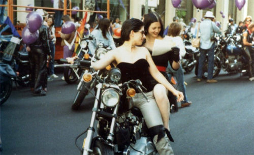 A lesbian couple shares a moment aboard a motorcycle before the 1983 Pride Parade in San Francisco.
