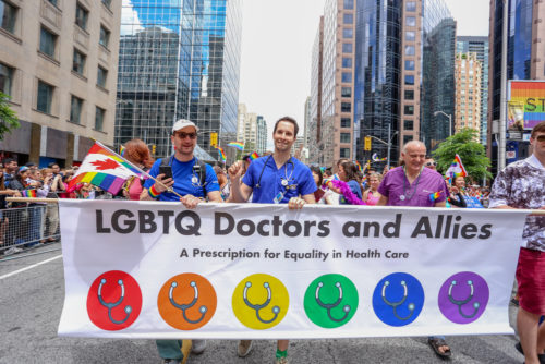 TORONTO, CANADA - JUNE 25, 2017: LGBTQ DOCTOS AND ALLIES march with banner that reads A PRESCRIPTION FOR EQUALITY IN HEALTH CARE at 2017 Toronto Pride Parade. TORONTO, CANADA - JUNE 25, 2017: LGBTQ DOCTOS AND ALLIES march with banner that reads A PRESCRIPTION FOR EQUALITY IN HEALTH CARE at 2017 Toronto Pride Parade.