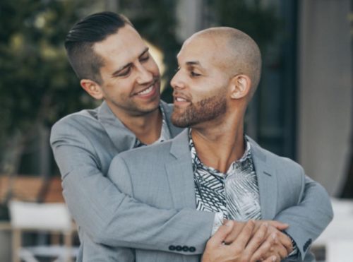 Two men in gray suits hugging