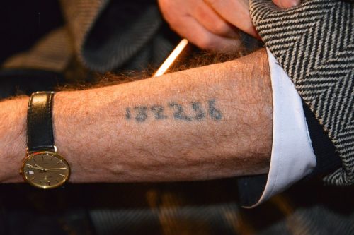 A Holocaust survivor displaying his arm tattoo. A Holocaust survivor displaying his arm tattoo.