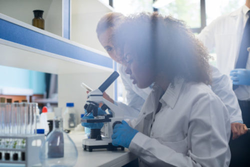 A scientist looking at a microscope