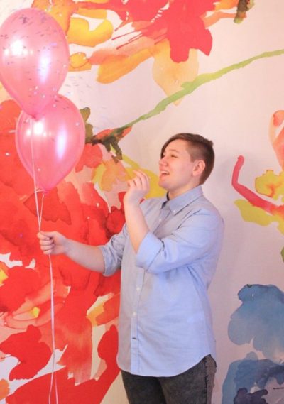 Adrian popping pink balloons