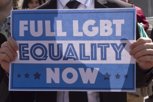 Asheville, North Carolina, USA - April 2, 2016: An activist holds a sign at a HB2 protest rally of a law that takes away the rights of the LGBTQ community. Asheville, North Carolina, USA - April 2, 2016: An activist holds a sign at a HB2 protest rally of a law that takes away the rights of the LGBTQ community.