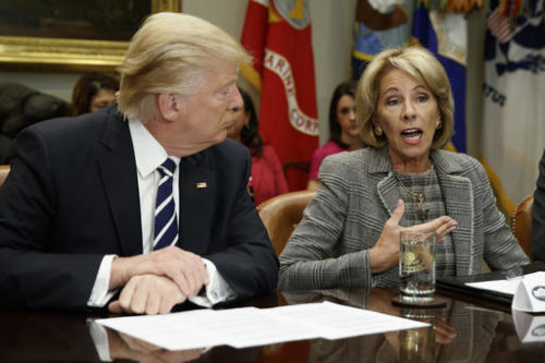President Donald Trump listens as Education Secretary Betsy DeVos speaks during a meeting with parents and teachers, Tuesday, Feb. 14, 2017, in the Roosevelt Room of the White House in Washington. Donald Trump and Betsy Devos