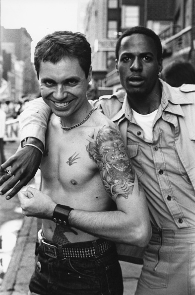 Portrait of a pair of parade-goers, one shirtless and tattooed, as they pose together during the Sixth Annual Gay Pride Day March (Gay Liberation Day), New York, New York, June 29, 1975. 