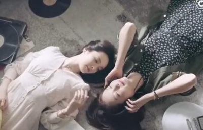 Two women lying on the floor, looking at each other lovingly