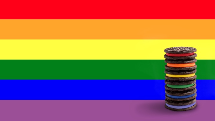 Limited edition Rainbow OREOs in front of the Pride flag.