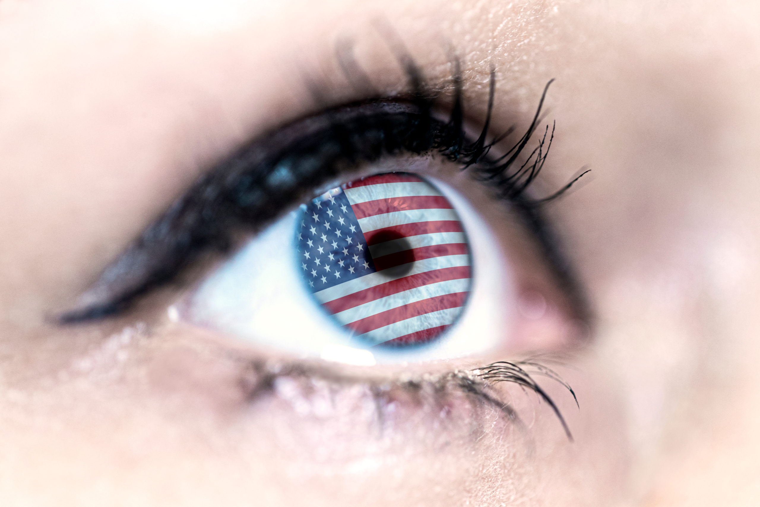 woman blue eye in close up with the flag of USA n in iris with wind motion. video concept