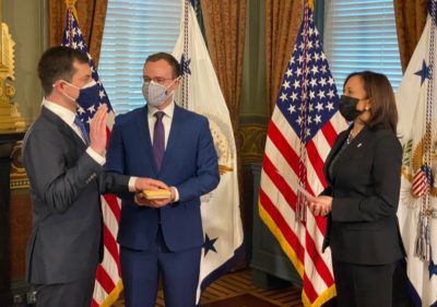 Pete Buttigieg getting sworn in by Kamala Harris with Chasten Buttigieg by his side.