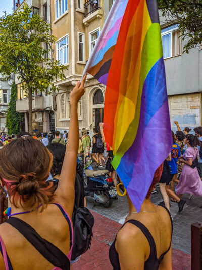 Two women, with one holding up a Progress Pride flag, during an unsanctioned march recognizing Pride in Istanbul, Turkey on June 17, 2021.