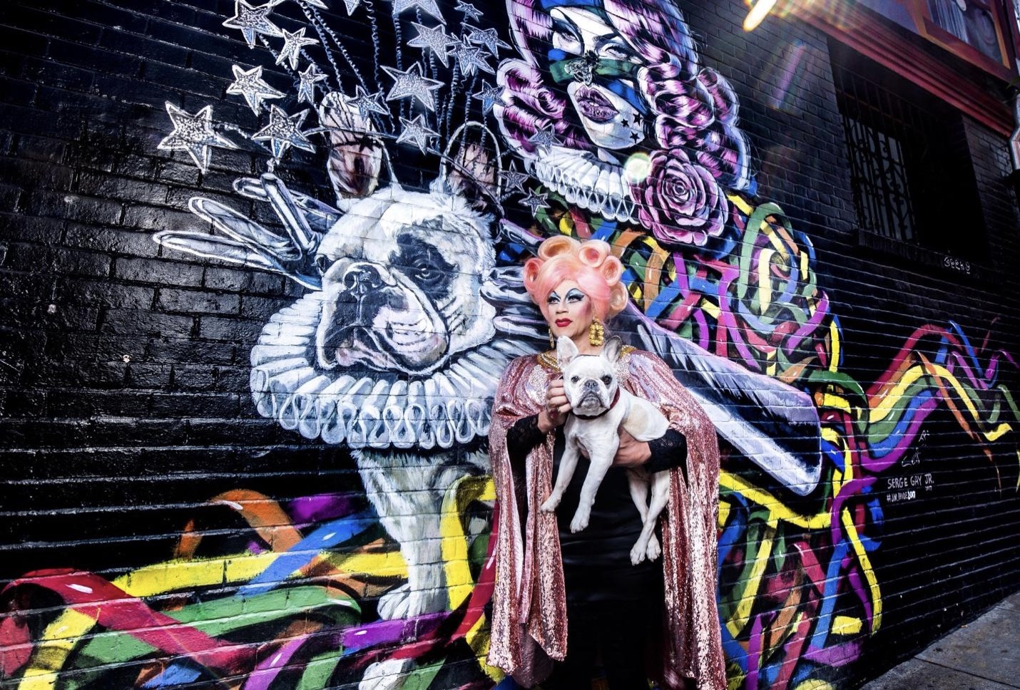 Juanita More and her dog, Jackson, in front of a mural in her honor on Fern Alley at Polk Street, one of many in San Francisco.