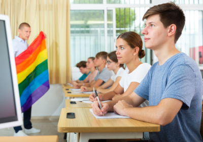 teen sitting up straight, teacher shows rainbow flag