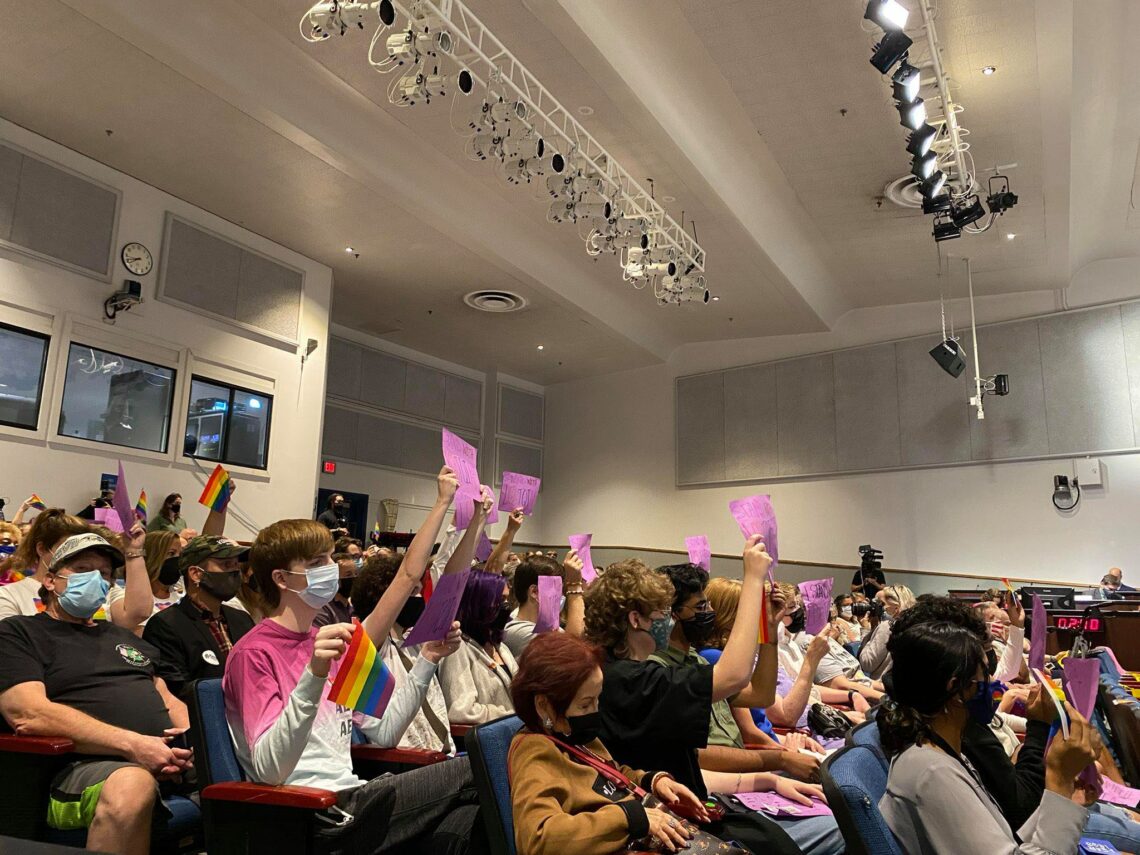 Students hold signs as parents protest that LGBTQ students are being treated equally