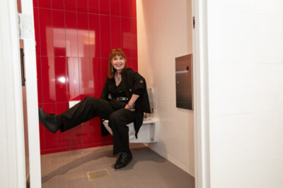 Elizabeth Coffey-Williams "breaking in" one of the gender-neutral bathrooms at the Baltimore Museum of Art's unveiling of "The John Waters Restrooms."