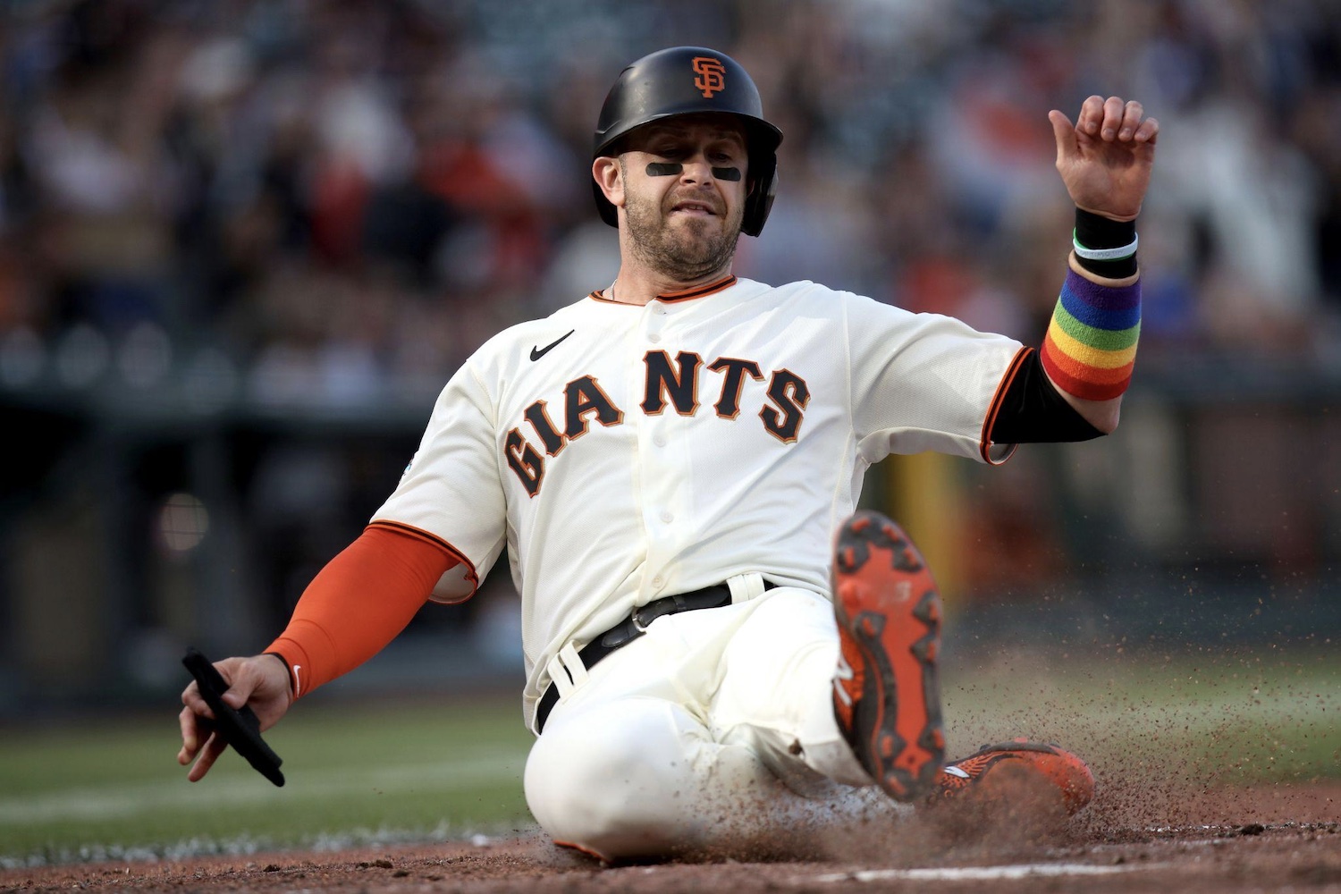 Giants third baseman Evan Longoria sliding into home wearing a rainbow armband on Pride Day at Oracle Park, June 5, 2021. Photo: Associated Press