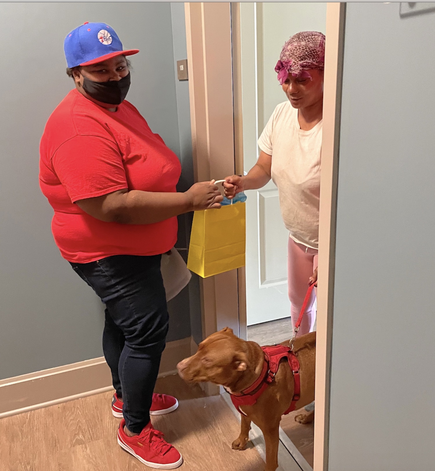 Michele (left) handing out a gift bag to a resident at the Gloria Casarez Residence. Courtesy of Project HOME.