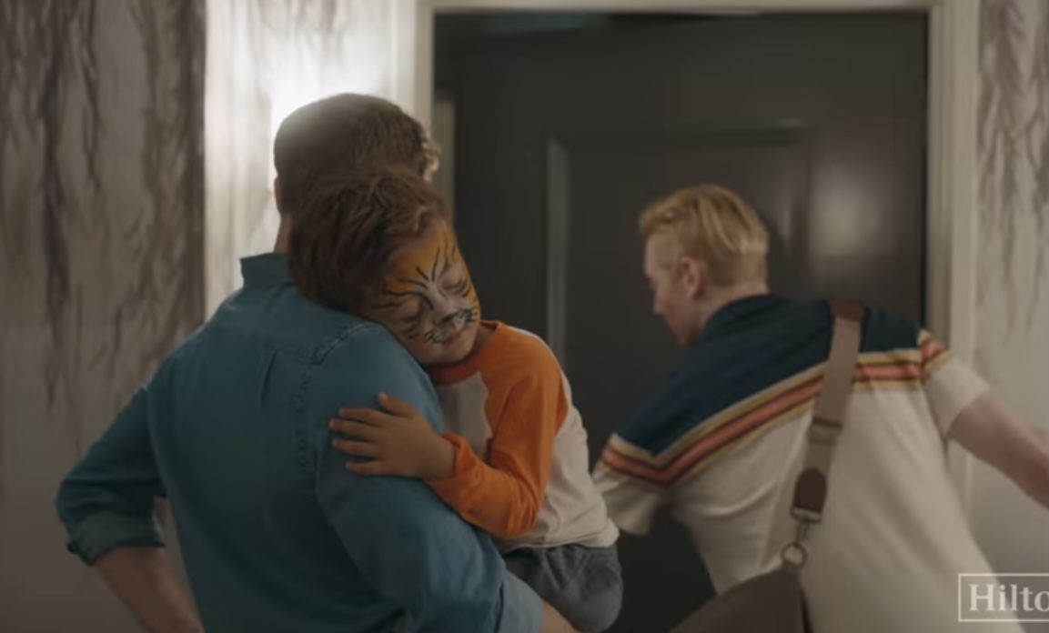 Anti-LGBTQ activists accuse hotel of trying to “normalize sin” with ad including two dads