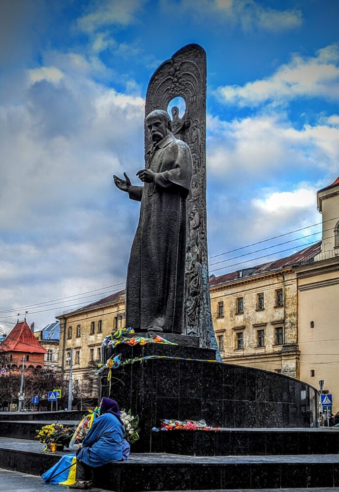 3/10/22: A woman sits alone in an empty square in central Lviv. 