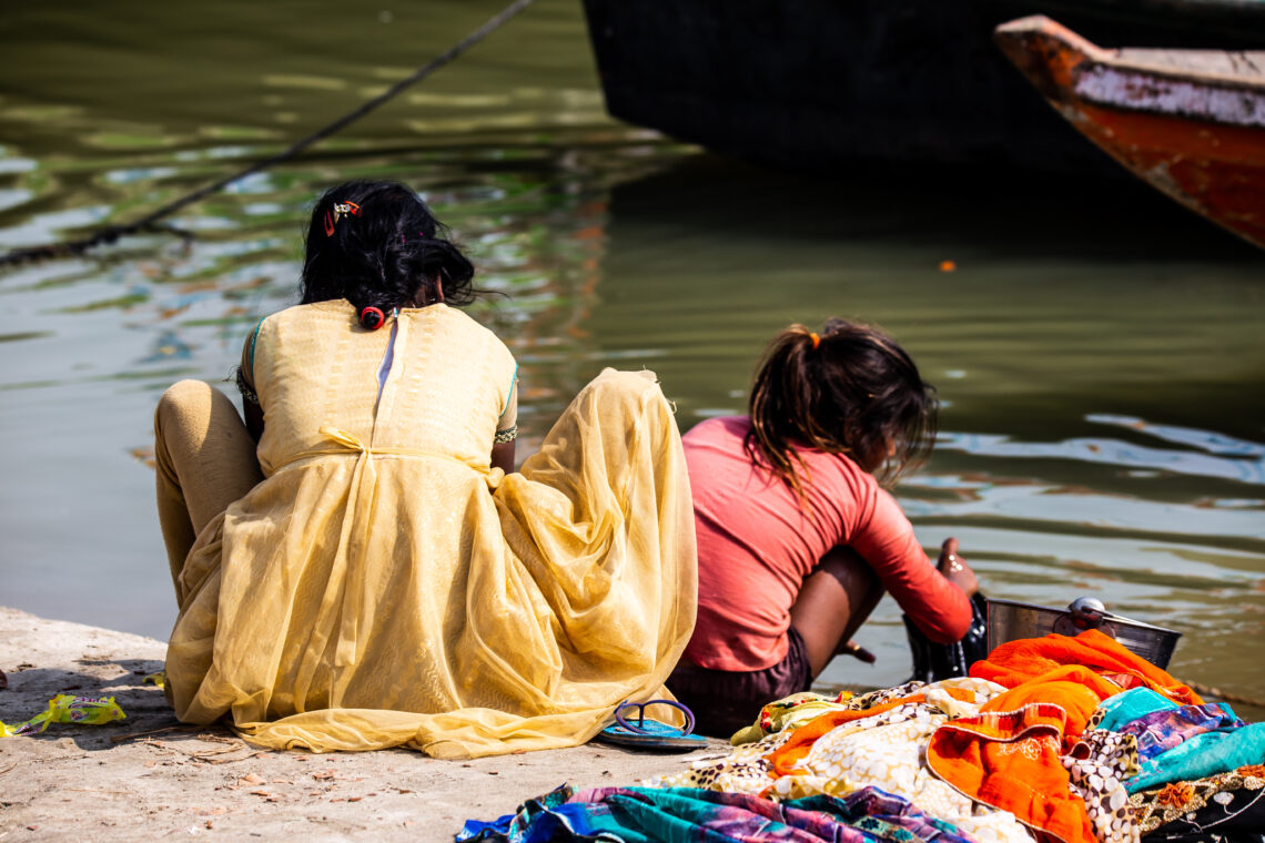 Mother and daughter of low caste washing their clothes in the Ganges river, in Varanasi, India.