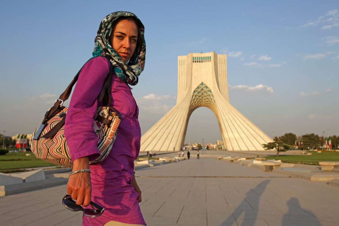 A woman walks near Azadi Tower in Tehran.