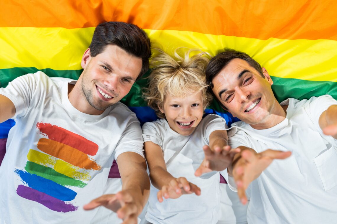 Lgbt family, gay couple with adopted son - Same-sex parents with their kid having fun at home, modern lgbtq family representation on daily life 